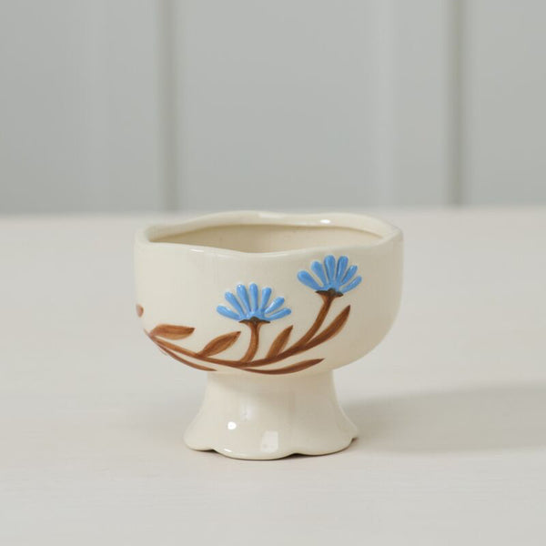 Small ceramic bowl with floral design on a white surface and light gray background