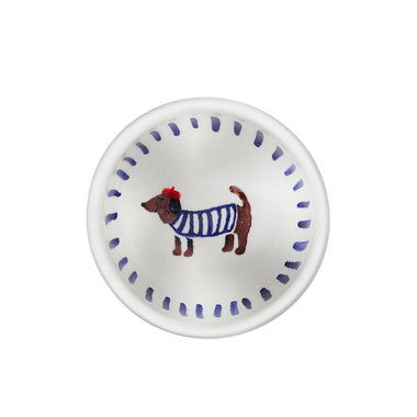 Small white plate with a dog illustration wearing a blue sweater on a white background