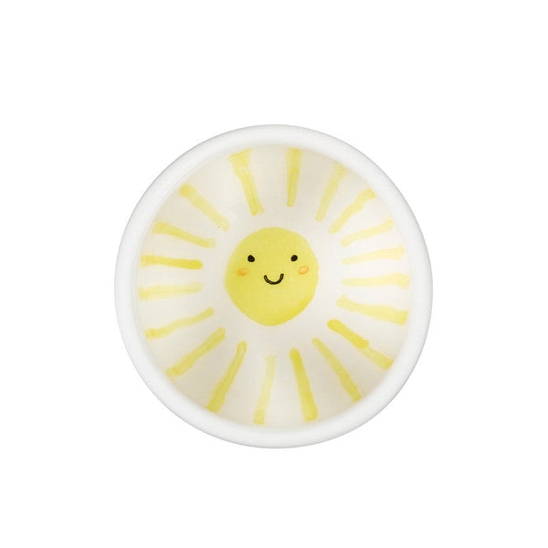 Round ceramic dish with a sun design on a white background